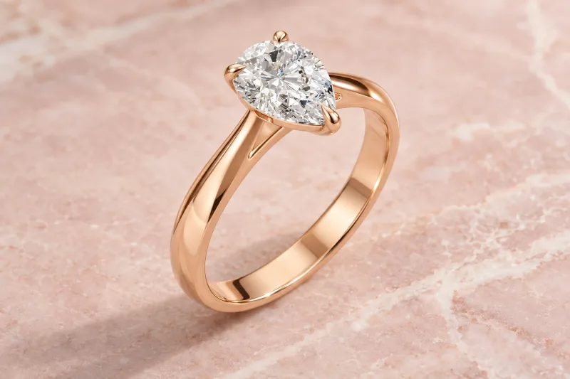 Bague solitaire Mireille poire en or rose 18 carats, composition éditoriale
